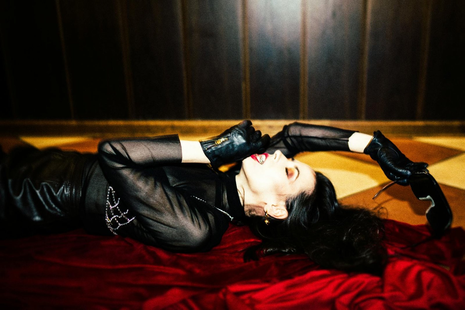 woman posing on bed in leather outfit