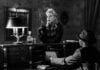 monochrome photo of woman leaning on counter top